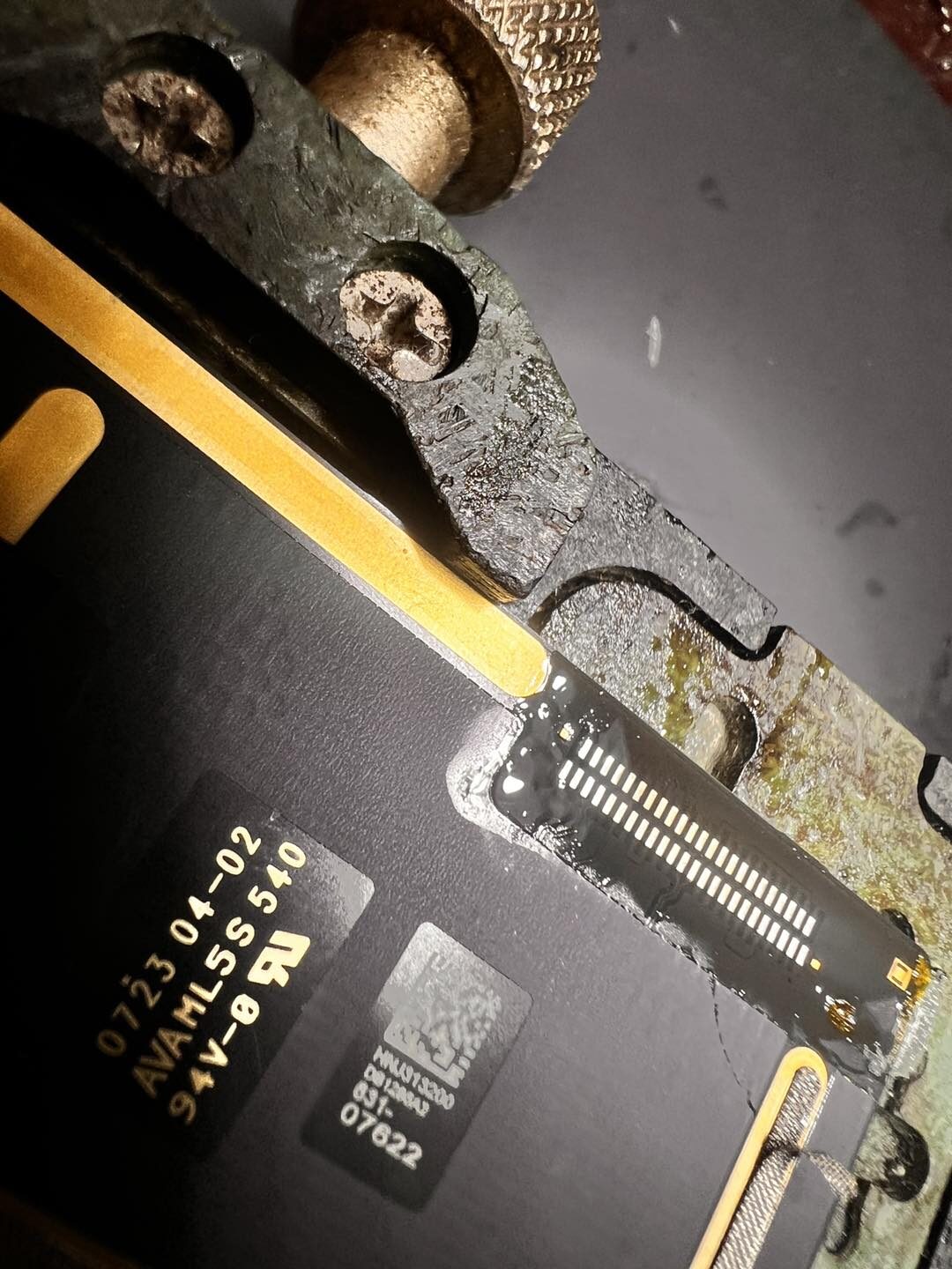 iPad logic board repair at the workshop bench showing micro-soldering work on a charging port